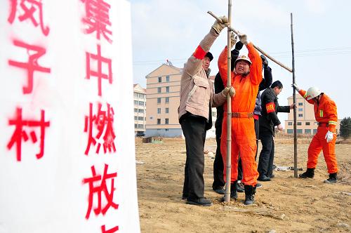 1月21日,山東省乳山市公安消防大隊在嵐子村設(shè)立的“春節(jié)煙花集中燃放點”和村民一起搭建掛放鞭炮的架子。新華社發(fā)(劉國賢 攝)