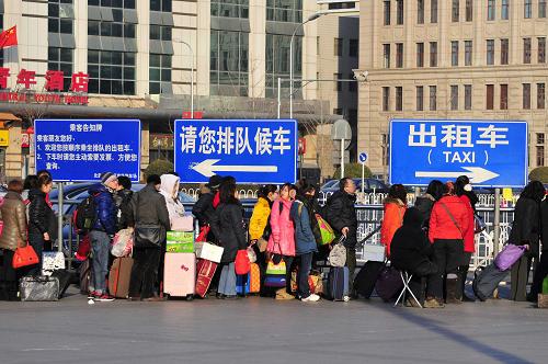 1月26日,在北京火車(chē)站前,大批抵達(dá)的旅客在排隊(duì)等候出租車(chē)。新華社發(fā)(樊甲山 攝)