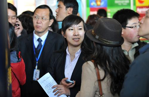 2月11日,一名招工企業(yè)代表(中)在昆明國際會展中心舉行的萬人招聘會上向求職者介紹情況。新華社記者 藺以光攝