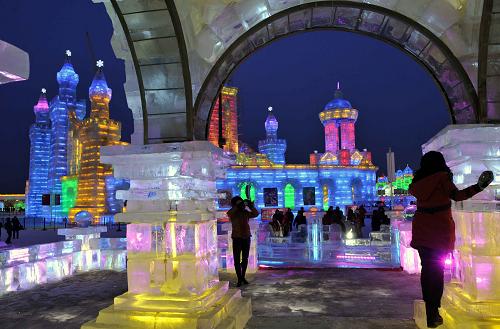 2月13日,在冰雪大世界園區(qū)內(nèi),游客在冰建筑中拍照。新華社記者 王建威 攝