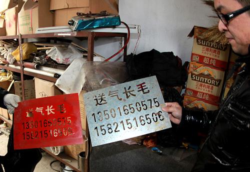 2月15日,聯(lián)合執(zhí)法人員在收繳非法送氣廣告牌。新華社記者 凡軍 攝