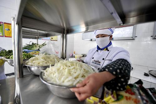 2月17日,在寧夏回族自治區(qū)隆德縣鳳嶺鄉(xiāng)馮碑小學(xué)的食堂內(nèi),工作人員將剛剛切好的菜擺上櫥柜準(zhǔn)備做午餐。新華社記者 彭昭之 攝