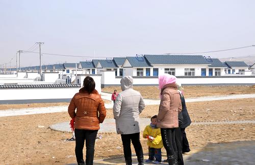 3月9日,在寧夏回族自治區(qū)靈武市郝家橋狼皮子梁涇靈新村,幾位村民眺望著新居。新華社發(fā)(李然攝)