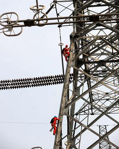 3月13日,浙江省湖州電力局工作人員在已完工的±800千伏錦蘇特高壓直流輸電工程浙江湖州段鐵塔上巡檢。新華社記者 徐昱 攝