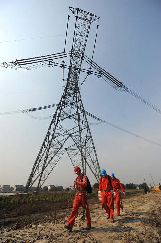 3月13日,浙江省湖州電力局工作人員在巡檢±800千伏錦蘇特高壓直流輸電工程浙江湖州段完工情況。新華社記者 徐昱 攝
