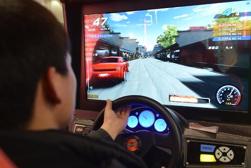 3月14日,參觀者在博覽會上體驗賽車游藝機。新華社記者李俊東攝