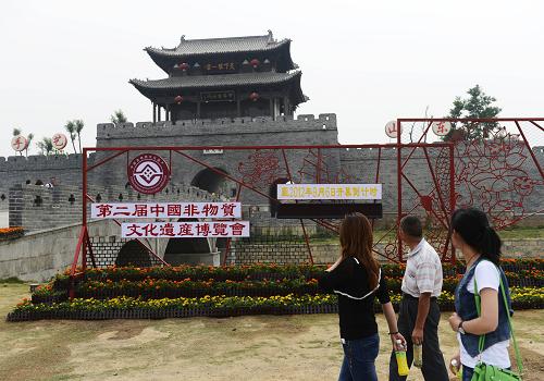 5月29日,在山東棗莊市臺兒莊古城,游客從第二屆中國非物質(zhì)文化遺產(chǎn)博覽會開幕倒計時牌前走過。新華社發(fā)(高啟民 攝)