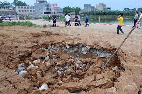 6月2日,在廣西南寧市西鄉(xiāng)塘區(qū)壇洛鎮(zhèn)壇洛村,人們從一個(gè)地陷坑旁經(jīng)過(guò)。當(dāng)日,記者從廣西南寧市西鄉(xiāng)塘區(qū)相關(guān)部門獲悉,西鄉(xiāng)塘區(qū)壇洛鎮(zhèn)所轄馬重、馬六、蘭楊、二甲4個(gè)自然村出現(xiàn)若干處不同程度的地陷,已轉(zhuǎn)移844名群眾,目前地陷程度未進(jìn)一步擴(kuò)大。據(jù)介紹,地陷地點(diǎn)位于西鄉(xiāng)塘區(qū)壇洛鎮(zhèn)壇洛二中附近,這一學(xué)校因用水緊張,請(qǐng)打井隊(duì)在校內(nèi)打井,6月1日晚7時(shí)許,壇洛二中校門口右側(cè)出現(xiàn)地面坍陷下沉約1.5米深、直徑2.5米的陷坑,石埠-壇洛縣級(jí)公路路面(36km+700至37km+200段)附近500米范圍內(nèi)壇洛村所轄馬重、馬六、蘭楊、二甲4個(gè)自然村出現(xiàn)若干處不同程度的沉陷。新華社記者 周華 攝