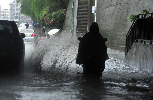 6月27日,在武漢市武昌區(qū),市民在雨中出行。新華社記者 肖藝九 攝