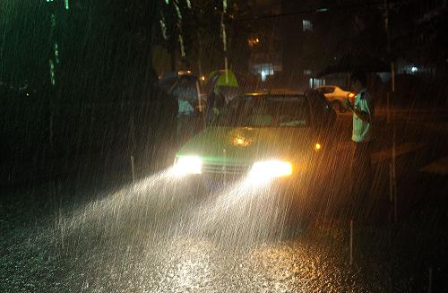 7月27日,石景山區(qū)魯谷社區(qū)的保安在大雨中執(zhí)勤。新華社記者 何俊昌 攝