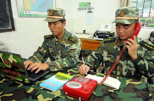武警某部官兵在福建省羅源縣設(shè)立的臨時(shí)簡(jiǎn)易指揮所內(nèi)進(jìn)行汛情通報(bào)(8月2日攝)。新華社記者 林善傳攝