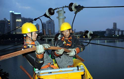 8月2日,九江供電公司電力工人在10千伏湖濱小區(qū)Ⅱ線進(jìn)行配網(wǎng)帶電作業(yè)。新華社記者 周科 攝