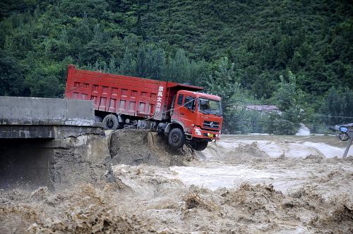 8月6日,湖北省??悼h牌坊灣橋被洪水沖斷,車輛懸在橋邊。8月5日晚至8月6日,湖北省保康縣遭遇持續(xù)暴雨襲擊,導(dǎo)致河水暴漲,牌坊灣橋被洪水沖斷,保康至宜昌、襄陽、十堰交通全部中斷。新華社發(fā)(王明瑞 攝)