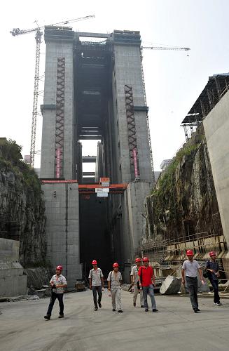 8月17日,升船機(jī)建設(shè)項(xiàng)目工程監(jiān)理人員在施工現(xiàn)場。據(jù)三峽集團(tuán)消息,三峽升船機(jī)頂部平臺板最后一倉混凝土日前完成澆筑,升船機(jī)船廂室段全線封頂。這標(biāo)志著三峽升船機(jī)主體結(jié)構(gòu)基本完成澆筑,工程建設(shè)取得重要進(jìn)展,施工將從以土建為主階段轉(zhuǎn)入以設(shè)備安裝為主階段。 三峽升船機(jī)將于2015年完全建成,屆時客運(yùn)船只可借助升船機(jī)“電梯式”直接通過三峽大壩。過壩時間可由現(xiàn)在的3個多小時縮短至40至60分鐘,大大提高船舶過壩效率。新華社發(fā)(鄭家裕 攝)