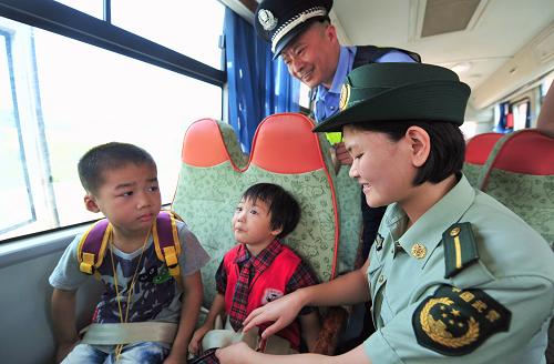 8月31日,福清市公安局干警和福清邊防大隊(duì)警官在校車上為福清三山紅橋幼兒園的小朋友們示范安全帶的使用方法。新華社記者 魏培全 攝