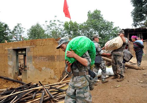 9月17日,駐滇部隊(duì)指戰(zhàn)員在地震災(zāi)區(qū)彝良縣云落村為受災(zāi)群眾運(yùn)送物資。新華社記者 楊宗友 攝