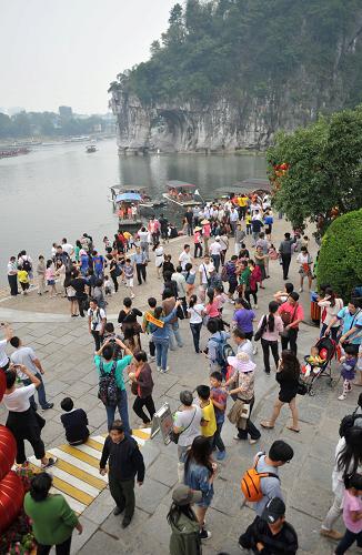 10月4日,游客在桂林市著名旅游景點(diǎn)象山景區(qū)游覽觀光。來(lái)自廣西桂林旅游部門統(tǒng)計(jì)顯示,9月30日至10月3日,桂林市各大景區(qū)旅游接待人數(shù)都呈逐步上升趨勢(shì),當(dāng)?shù)?#8220;黃金周”旅游漸入高峰。其中3日一天,乘船游覽漓江景區(qū)的游客達(dá)1.36萬(wàn)人次,遠(yuǎn)遠(yuǎn)超出1萬(wàn)人的單日最佳接待量。新華社記者陸波岸攝