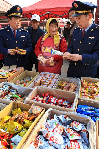 10月31日,在即墨市鰲山衛(wèi)鎮(zhèn)集市上,工商執(zhí)法人員在向攤販詢問食品進貨渠道。新華社記者李紫恒攝