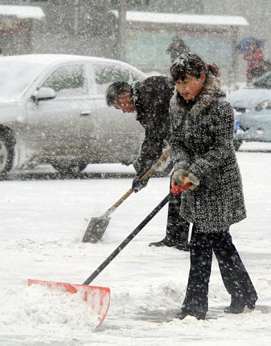 11月26日,新疆阿勒泰市市民在清掃積雪。新華社發(fā)(唐曉波 攝)
