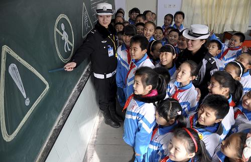 11月29日,邯鄲交警支隊六大隊女子中隊的民警在指導(dǎo)叢臺小學(xué)的學(xué)生們識別交通標(biāo)志。新華社發(fā)(郝群英 攝)