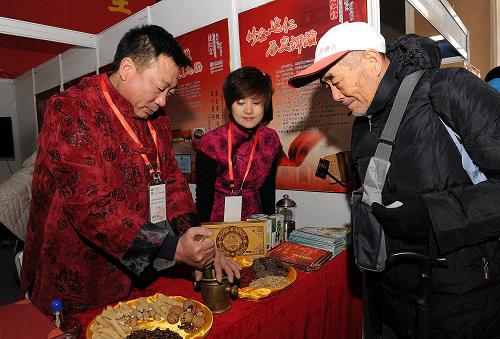 12月6日,參展商向來賓演示中藥加工。新華社記者 何俊昌 攝