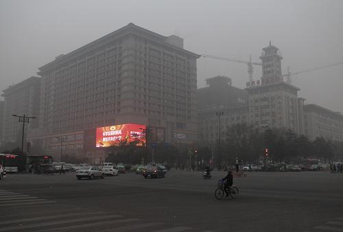 12月15日中午,陰霾籠罩西安市西華門(mén)建筑物。新華社記者 丁海濤 攝