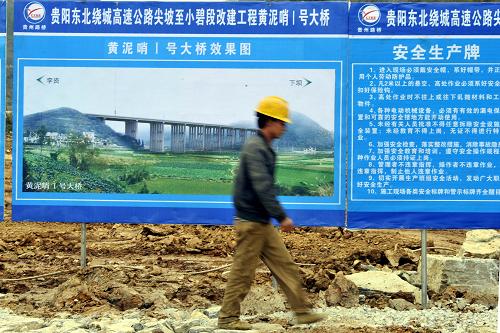 12月16日,貴陽東北繞城高速公路尖坡至小碧段施工現(xiàn)場,一建筑工人從效果圖前走過。當(dāng)日,隨著貴陽東北繞城高速公路尖坡至小碧段的開工,貴州省近期陸續(xù)開工的總投資1093億元、總長1073公里的13條高速公路全部進入建設(shè)階段。未來三年,貴州將完成近4000億元高速公路建設(shè)投資,新建成高速公路2500公里以上。到2015年,貴州將實現(xiàn)高速公路通車里程5100公里以上,高速公路路網(wǎng)密度達每百平方公里2.84公里,屆時貴州將形成高速公路骨干網(wǎng)絡(luò),推動工業(yè)化、信息化、城鎮(zhèn)化、農(nóng)業(yè)現(xiàn)代化同步發(fā)展。新華社記者歐東衢攝