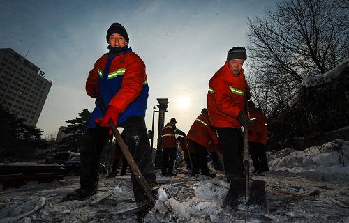 12月16日,環(huán)衛(wèi)工人在長春市街頭清掃積雪。 12月15日,吉林省長春市又飄起小雪。16日一早,長春市朝陽區(qū)的1000多名環(huán)衛(wèi)工人們?nèi)蔽溲b“集結(jié)”起來,清掃新民大街路段的人行橫道上的積雪。環(huán)衛(wèi)工人們用鐵鍬、大掃帚、推雪板費(fèi)力地除雪,他們橙紅色的身影帶給冬日一絲溫馨暖意。新華社記者許暢攝