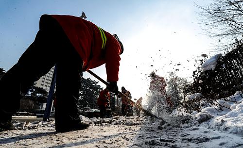 12月16日,一名環(huán)衛(wèi)工人在鏟去路面被壓實(shí)的積雪。新華社記者許暢攝