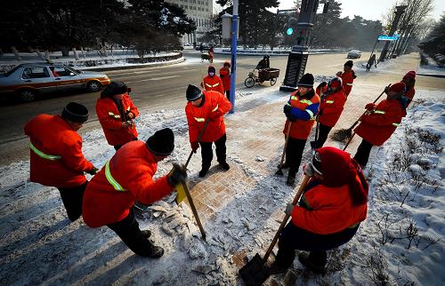 12月16日,經(jīng)過環(huán)衛(wèi)工人們的清掃,人行橫道的路面已經(jīng)“露”了出來。新華社記者許暢攝
