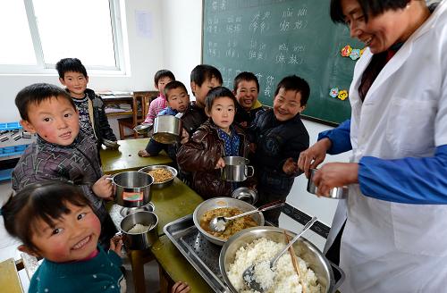 12月19日,青龍滿族自治縣七道河鄉(xiāng)后水河小學的廚師在給孩子們盛飯。新華社記者 楊世堯 攝