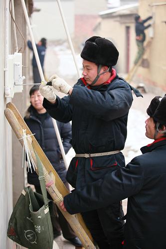 12月20日,國家電網(wǎng)天津?qū)幒庸竟ぷ魅藛T為造甲城鎮(zhèn)造甲城村農(nóng)戶更換智能電表。新華社發(fā)(任麗華 攝)