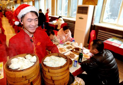 12月21日,沈陽一家餃子館的工作人員為顧客端上熱騰騰的餃子。新華社發(fā)