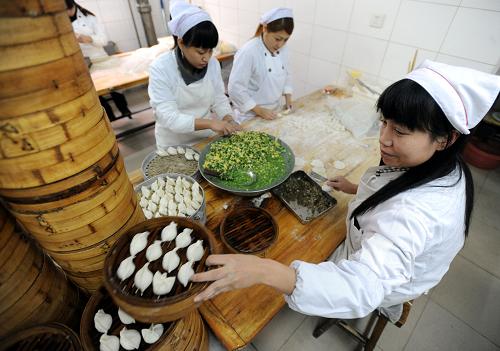 12月21日,沈陽一家餃子館的工作人員在后廚包餃子。新華社發(fā)