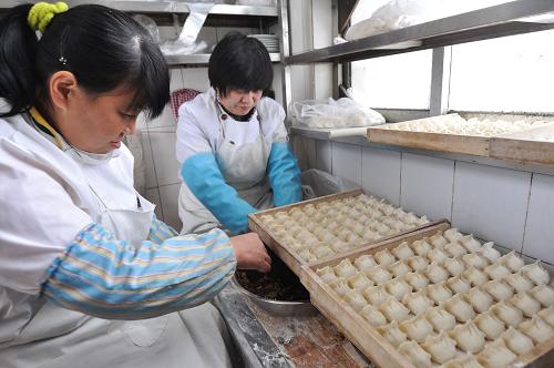 12月21日,山東省濱州市鄒平縣一家餃子館的工作人員在包餃子。新華社發(fā)(董乃德 攝)