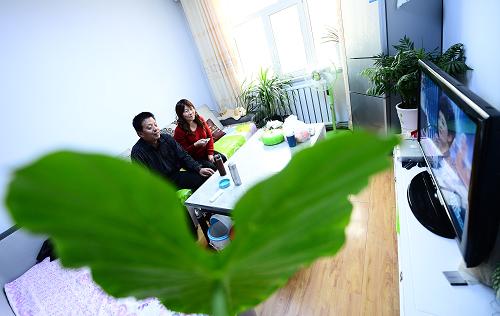 在青海省樂(lè)都縣一處保障房小區(qū)內(nèi),王建元(左)和袁世蓮夫婦在自己家中看電視。新華社記者 張宏祥 攝