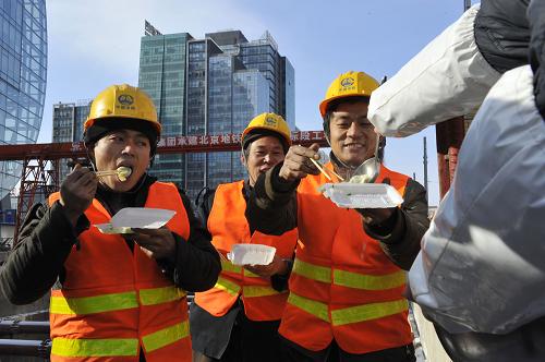 12月21日,在北京地鐵15號線一期工程安立路站工地上,工人們在午餐時(shí)間吃到公司送來的熱氣騰騰的“冬至餃子”。新華社記者 魯鵬 攝