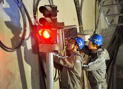 12月21日,重慶軌道交通集團運營通號公司的兩名技術工在隧道內(nèi)對通行信號設備進行日常檢修。新華社記者 劉潺 攝