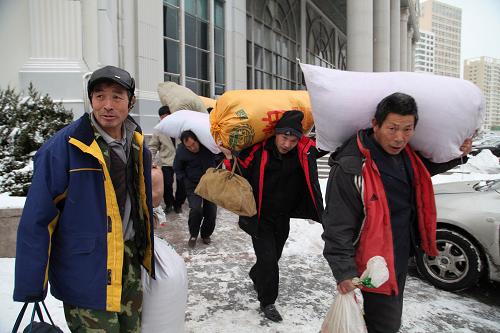 12月23日,由于降雪,威海市汽車站部分方向客車暫時停班,幾名準備返鄉(xiāng)的外來務工人員走出汽車站候車大廳,準備包車回家。新華社發(fā)(于啟波 攝)