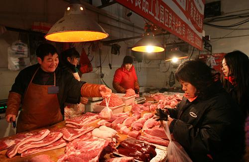 12月25日,顧客在北京西城區(qū)一家農貿市場內選購鮮豬肉。新華社記者劉蓮芬攝