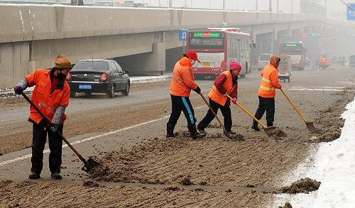 1月21日,環(huán)衛(wèi)工人在石家莊市中華大街清理路上積雪。近日的降雪天氣給石家莊市民的出行帶來不便。為了確保道路暢通,早日為市民提供一個(gè)良好的出行環(huán)境,石家莊市5000余名環(huán)衛(wèi)工人上路進(jìn)行融雪清雪作業(yè)。新華社發(fā)(朱旭東 攝)