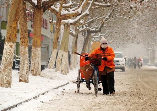 1月21日,環(huán)衛(wèi)工人在石家莊市和平路上推車撒放融雪鹽。新華社發(fā)(朱旭東 攝)