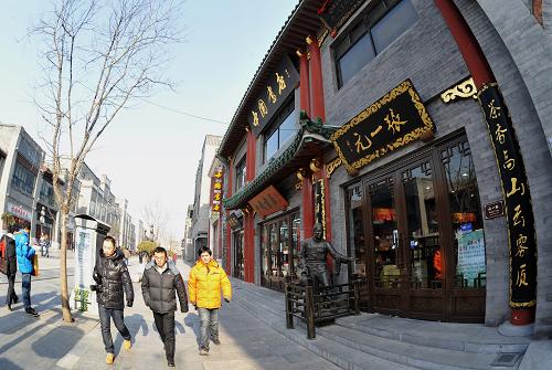 前門大街上的老字號(hào)商家(1月21日攝)。2008年,經(jīng)過大規(guī)模修繕的北京市前門大街重新開街。4年多來,前門大街已有13家原生地老字號(hào)回遷,并引進(jìn)了錦芳、烤肉季等22家知名老店。這35家老字號(hào)門店讓人們?cè)诠浣值耐瑫r(shí)還能飽覽北京歷史文化,其中有10余家老字號(hào)還開辟出文化展示區(qū)域,把老物件、老技藝免費(fèi)展現(xiàn)給市民和游客。北京東城區(qū)前門大街管委會(huì)介紹,前門地區(qū)曾匯集4000余家商號(hào),形成了老北京商賈誠信、精良的文化。在未來的規(guī)劃中,將進(jìn)一步推動(dòng)老字號(hào)品牌聚集,按照“保留、恢復(fù)、引進(jìn)、扶持”的思路來發(fā)展前門大街,洋品牌、時(shí)尚品牌將不再是前門大街招商重點(diǎn)。新華社記者 李欣 攝