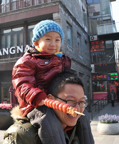 一對(duì)父子在前門大街游玩(1月21日攝)。新華社記者 李欣 攝