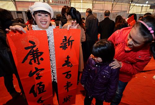 1月22日,市民在福清市舉辦的“迎新春反腐倡廉宣傳教育活動”上展示當(dāng)?shù)貢椰F(xiàn)場書寫的春聯(lián)。新華社記者 張國俊 攝