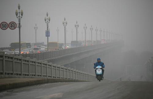 1月22日,市民在雨霧中的南京長(zhǎng)江大橋上騎行。新華社發(fā)