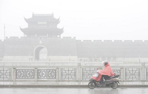 1月22日,一名市民在雨霧中的蘇州街頭騎行。新華社發(fā)