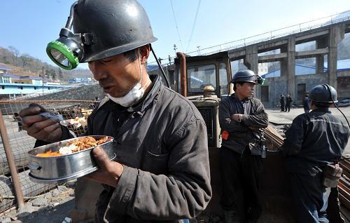 1月22日,在貴州盤江精煤股份有限公司金佳礦煤與瓦斯突出事故現(xiàn)場,救援人員在休息時吃盒飯。新華社記者 楊楹 攝