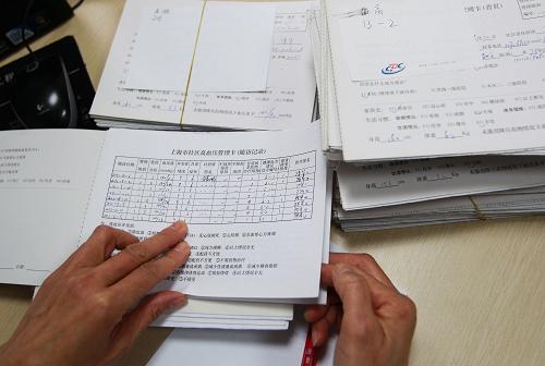 1月22日,上海市長寧區(qū)周家橋街道社區(qū)衛(wèi)生服務(wù)中心的家庭醫(yī)生陳華在整理社區(qū)居民的健康狀況管理卡片。新華社發(fā)(丁汀 攝)