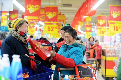 1月23日,領(lǐng)到愛心卡的群眾在超市內(nèi)選購年貨。新華社發(fā)(孟德龍 攝)